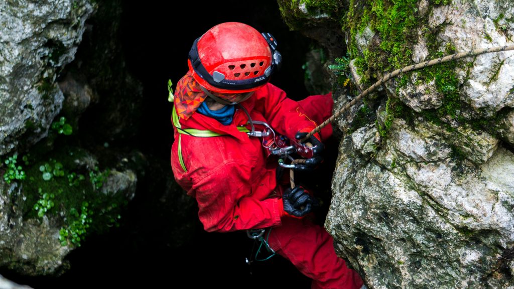 Ein Forscher Seilt sich in eine Höhle ab.